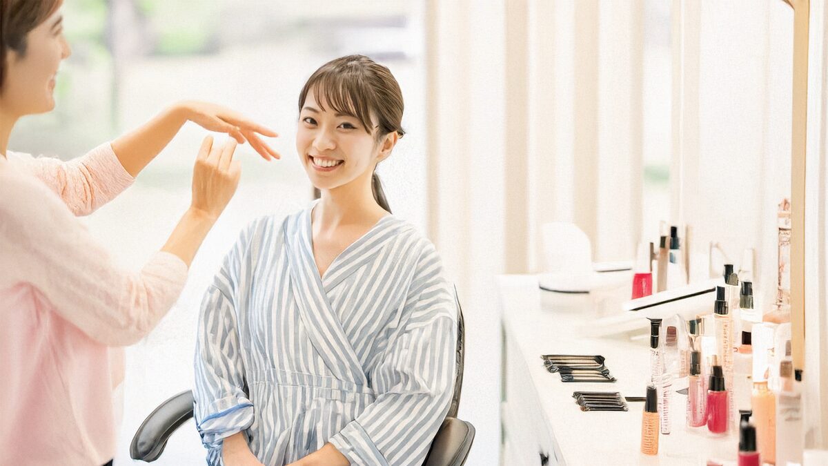 美容サロンで施術を行うスタッフの様子。リラックスした顧客と、丁寧に接客する技術者が映っている。